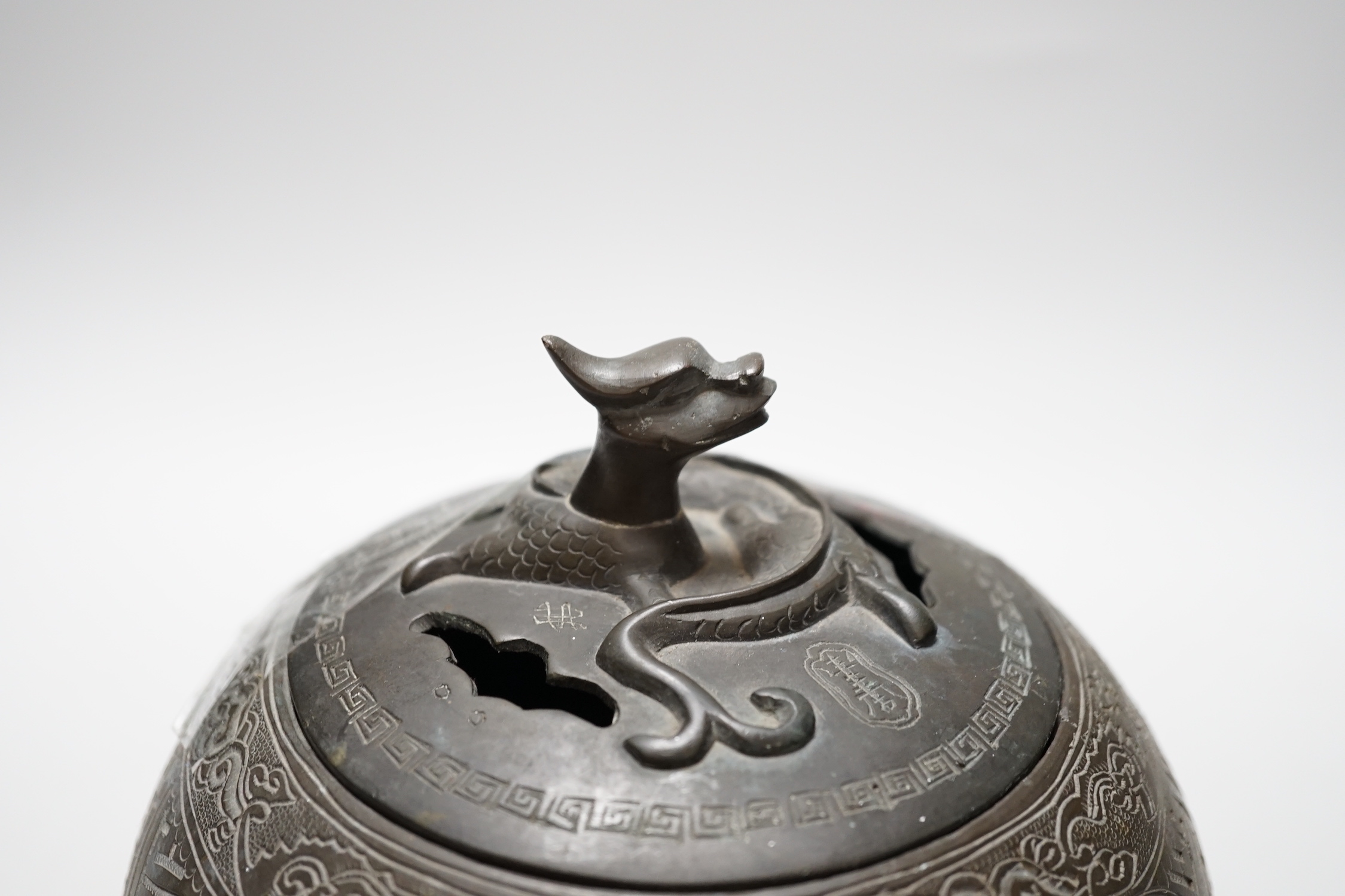 A Chinese three footed cast and chased bronze globular censer and cover, c.1900, 20cm high